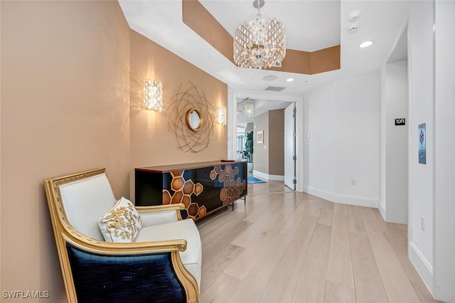 hallway featuring hardwood / wood-style flooring and an inviting chandelier