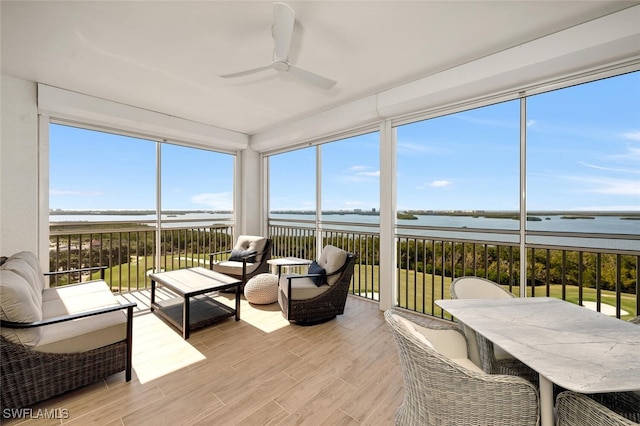 sunroom with a water view and ceiling fan