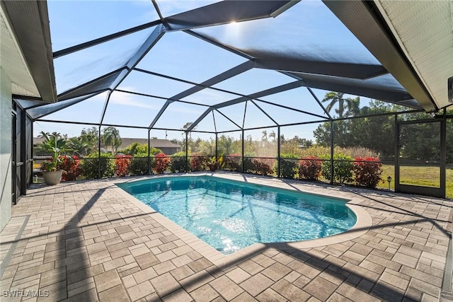 view of pool with a patio and glass enclosure