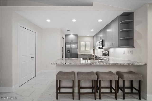 kitchen with gray cabinetry, sink, stainless steel appliances, and kitchen peninsula