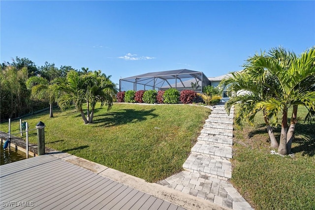 view of yard featuring a lanai, a dock, and a water view