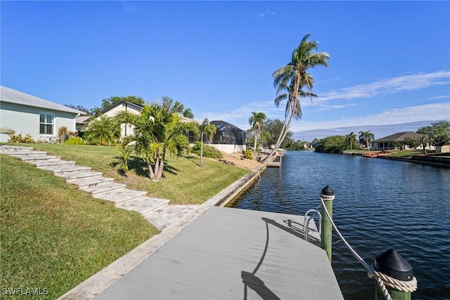 view of dock featuring a lawn and a water view