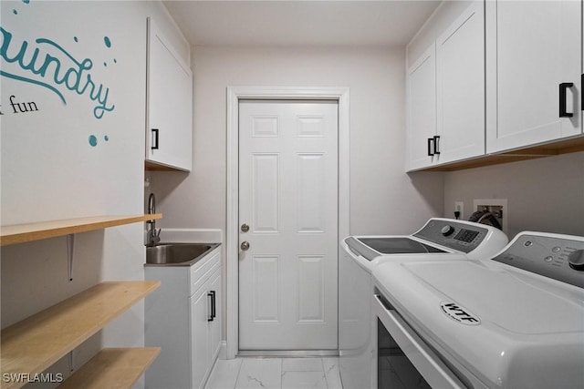 laundry room with cabinets, separate washer and dryer, and sink