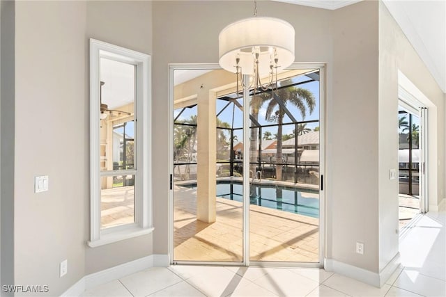 doorway to outside with light tile patterned floors, baseboards, and a chandelier