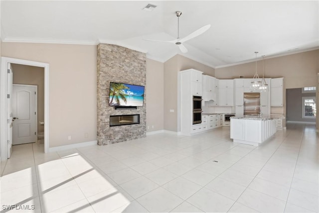 unfurnished living room with light tile patterned flooring, visible vents, ornamental molding, and a stone fireplace