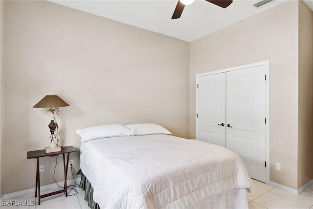 bedroom featuring light tile patterned flooring, a ceiling fan, visible vents, baseboards, and a closet