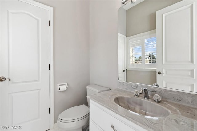 half bathroom featuring toilet and vanity