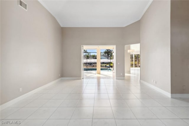 spare room featuring light tile patterned floors, baseboards, visible vents, and crown molding