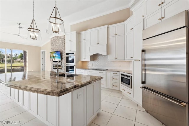 kitchen with built in appliances, a spacious island, a sink, and white cabinetry