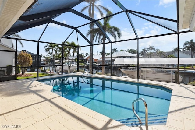 pool with glass enclosure, a patio, and a water view