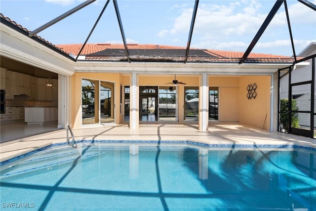 outdoor pool with a ceiling fan, a lanai, and a patio