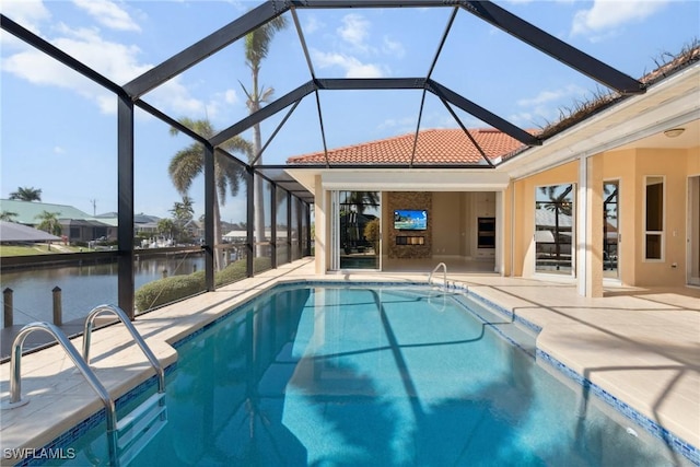 outdoor pool featuring a patio area, a water view, and a lanai