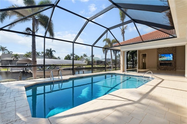 outdoor pool featuring a patio area, glass enclosure, and a water view