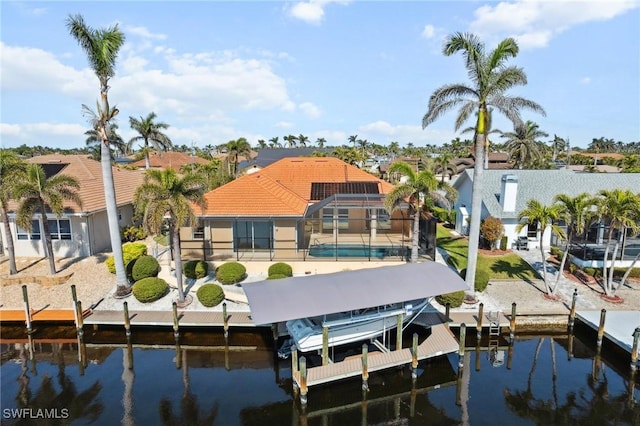 dock area with a lanai, a water view, boat lift, and an outdoor pool