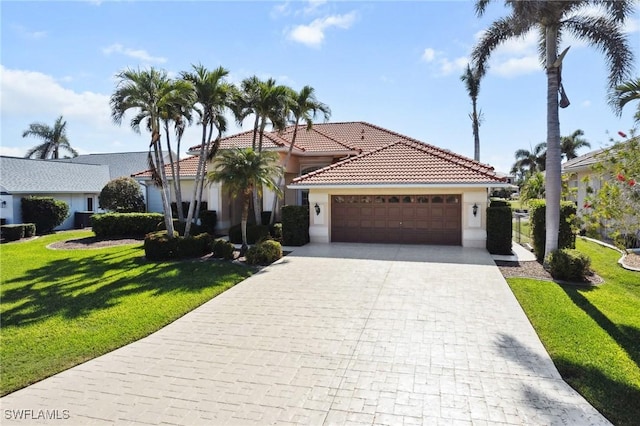 view of front facade featuring a garage, a tiled roof, decorative driveway, stucco siding, and a front yard