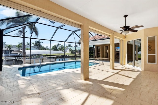 pool with ceiling fan, a patio, a water view, and a lanai