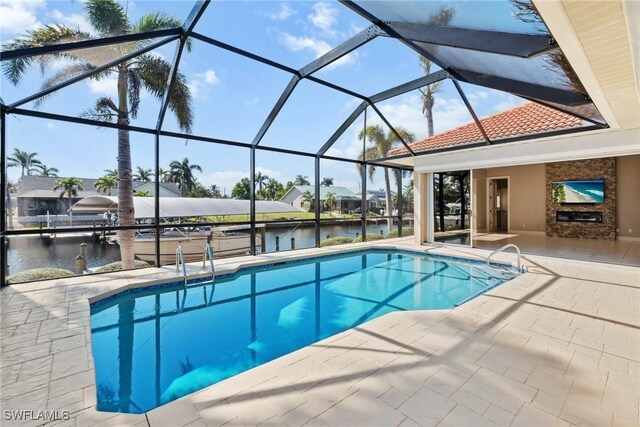 outdoor pool with a lanai, a water view, and a patio