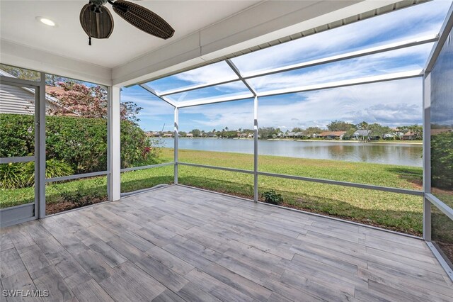 unfurnished sunroom with a water view and ceiling fan