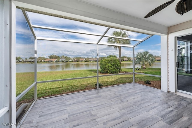 unfurnished sunroom with a water view and ceiling fan