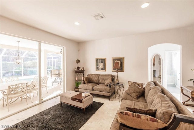 living room featuring light tile patterned flooring and an inviting chandelier