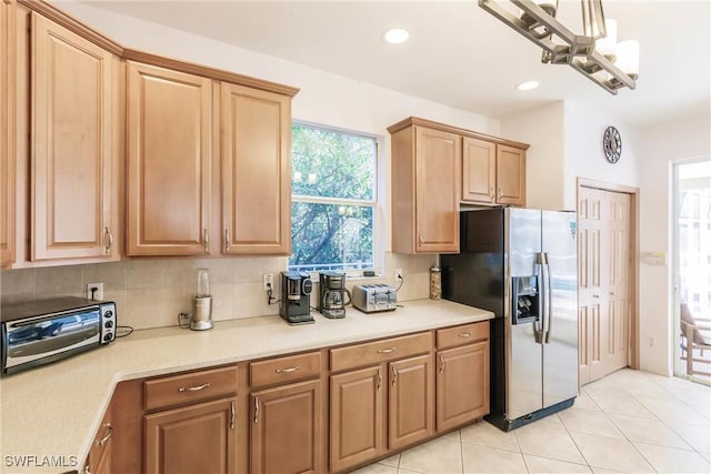 kitchen with a chandelier, stainless steel fridge with ice dispenser, decorative backsplash, and light tile patterned floors