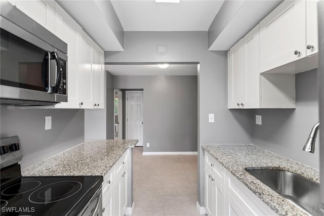 kitchen with stainless steel appliances, sink, and white cabinets