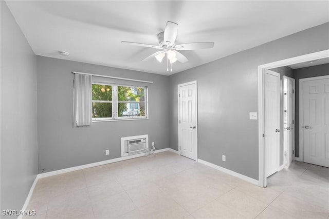 unfurnished room with a wall unit AC and ceiling fan