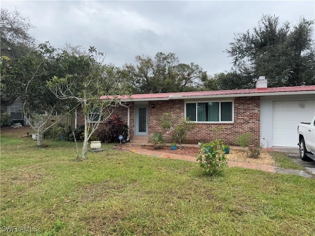 ranch-style house with metal roof, an attached garage, brick siding, a front lawn, and a chimney