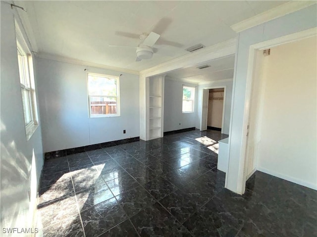 spare room featuring ornamental molding, visible vents, ceiling fan, and baseboards