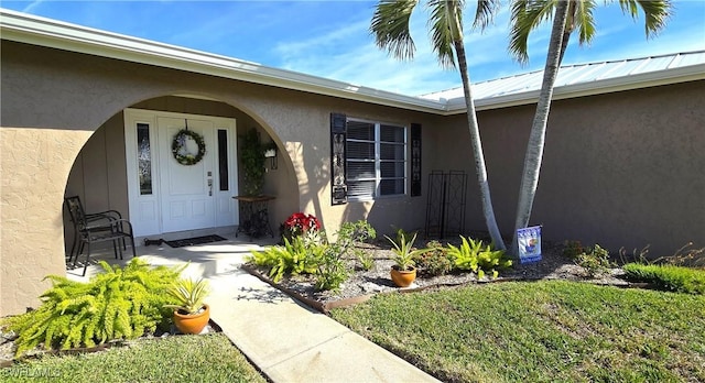 doorway to property with a lawn