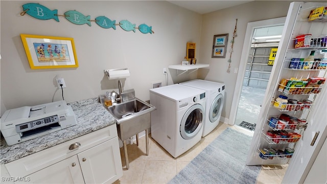 clothes washing area featuring cabinets, independent washer and dryer, sink, and light tile patterned floors