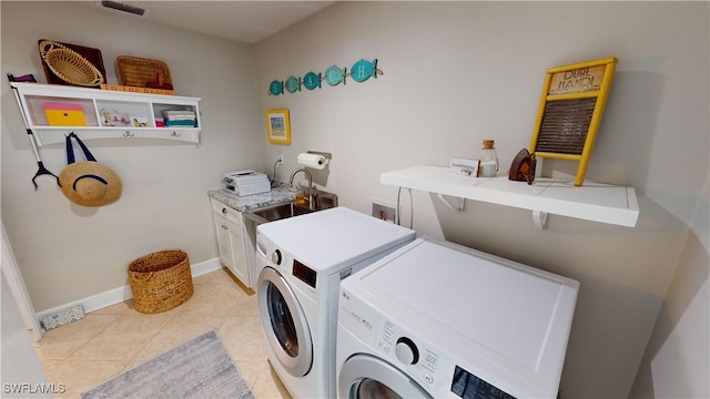 clothes washing area featuring cabinets, sink, light tile patterned floors, and independent washer and dryer