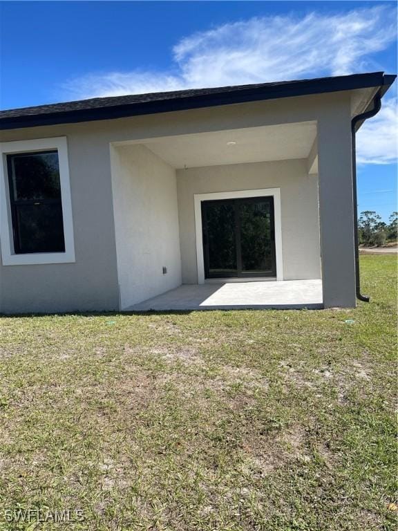 rear view of house with a yard and a patio area