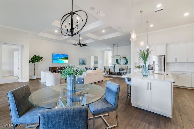 dining area featuring ceiling fan with notable chandelier, ornamental molding, dark hardwood / wood-style floors, and sink