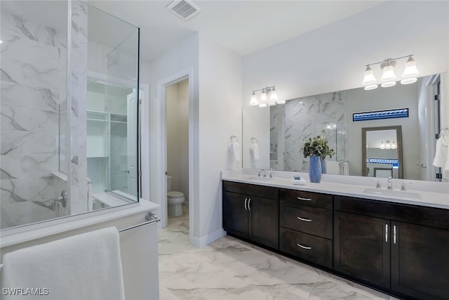 bathroom with toilet, vanity, and a tile shower