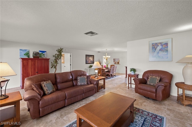 living room with an inviting chandelier and a textured ceiling