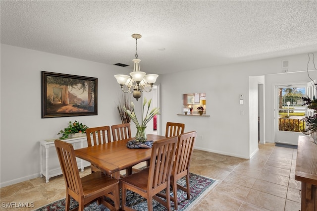 dining area featuring a textured ceiling and a chandelier