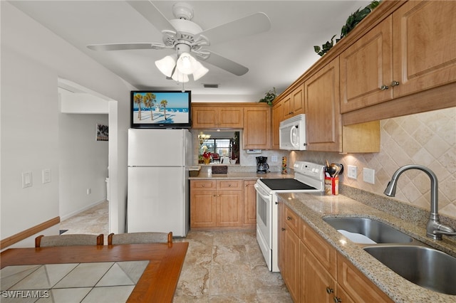 kitchen with sink, white appliances, ceiling fan, light stone counters, and decorative backsplash