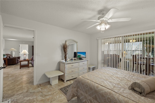 bedroom with ceiling fan and a textured ceiling