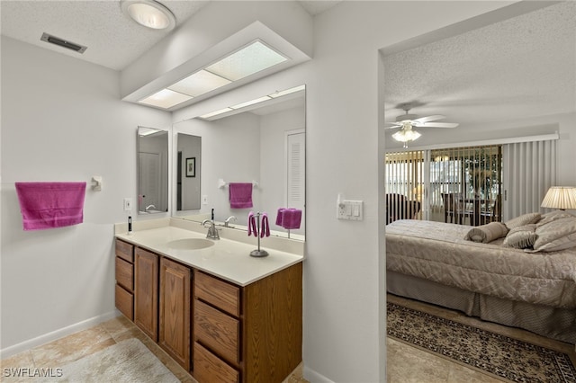 bathroom featuring vanity, ceiling fan, and a textured ceiling