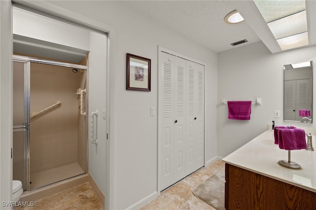 bathroom featuring vanity, toilet, a textured ceiling, and walk in shower