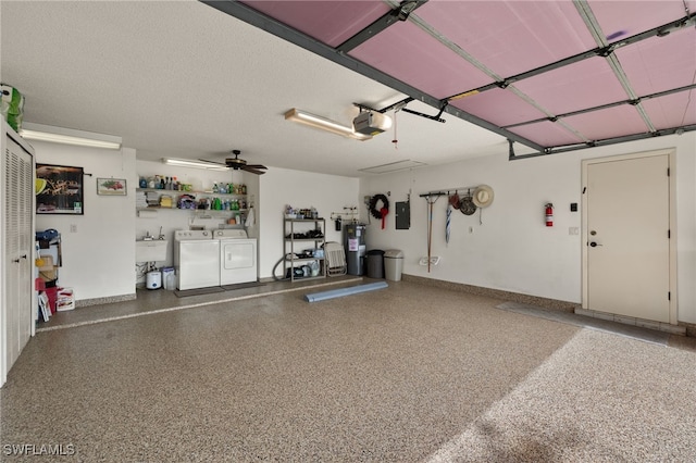 garage with a garage door opener, sink, separate washer and dryer, electric panel, and water heater