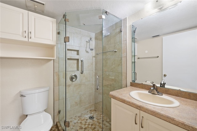 bathroom featuring vanity, toilet, and a shower with shower door