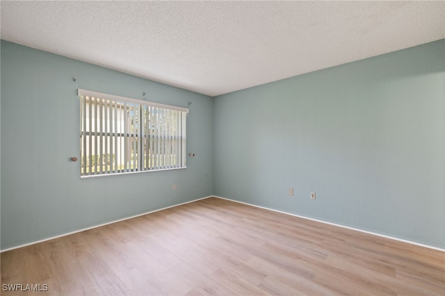 empty room featuring light hardwood / wood-style flooring and a textured ceiling