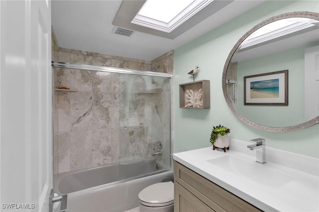 full bathroom with enclosed tub / shower combo, vanity, toilet, and a skylight