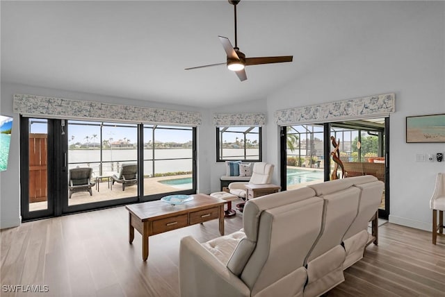 living room with ceiling fan, vaulted ceiling, and light hardwood / wood-style flooring