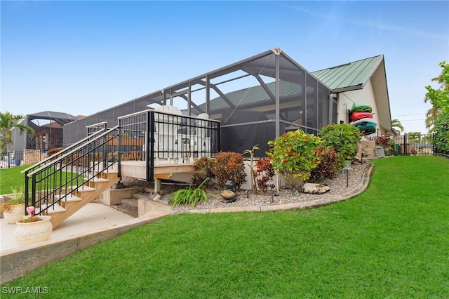 rear view of property featuring a yard and a lanai