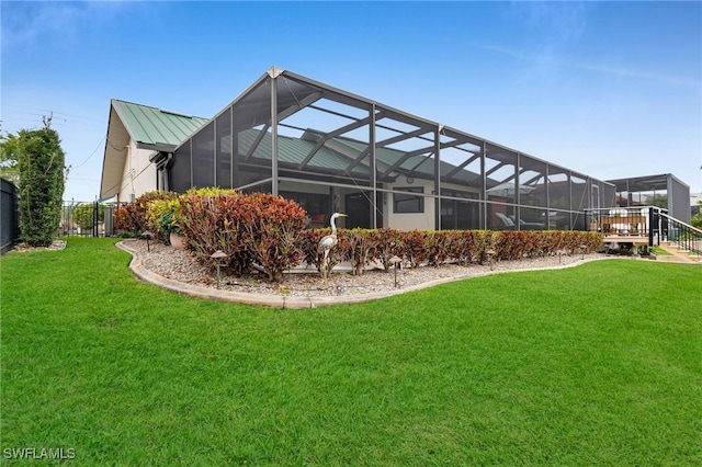 rear view of property featuring a yard, a deck, and a lanai