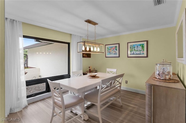 dining room with ornamental molding and wood-type flooring