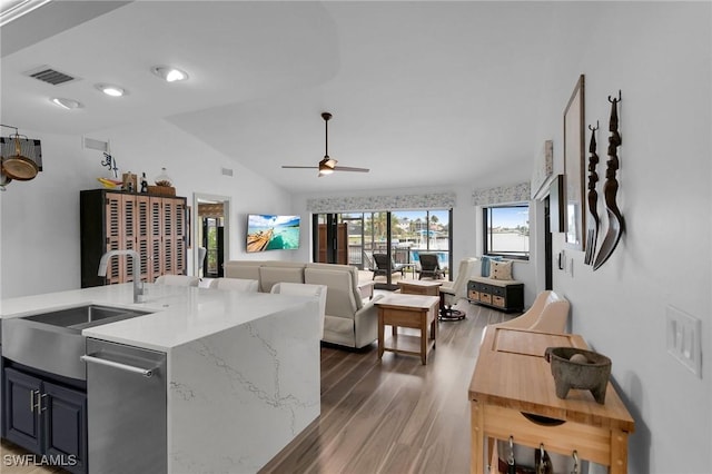 kitchen with dark hardwood / wood-style floors, lofted ceiling, sink, light stone counters, and ceiling fan